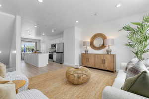 Living room with light wood-type flooring, recessed lighting, and a textured ceiling