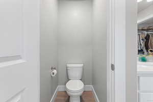 Bathroom featuring wood finished floors and a walk in closet