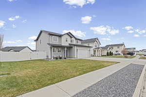View of front of house with driveway, a residential view, covered porch, and a garage