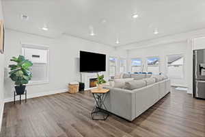 Living room featuring a lit fireplace and dark wood finished floors