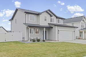 Traditional-style house featuring a garage, a porch, concrete driveway, a gate, and a shingled roof