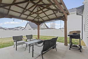 Fenced backyard featuring a patio, area for grilling, and a gazebo