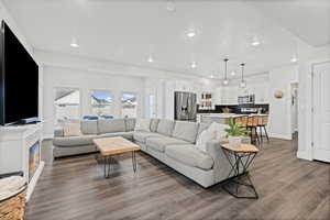 Living area with a glass covered fireplace, dark wood-style floors, and recessed lighting