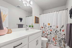 Full bath with vanity and a shower with shower curtain