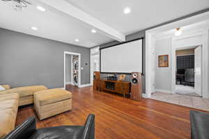 Cinema with recessed lighting, light wood-style flooring, and beamed ceiling