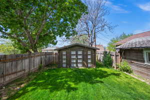 Fenced backyard with a man cave or she shed