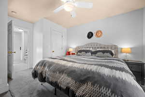 Carpeted bedroom featuring a ceiling fan