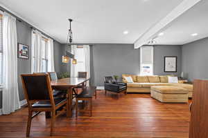 Dining room featuring dark wood finished floors, recessed lighting, and beamed ceiling