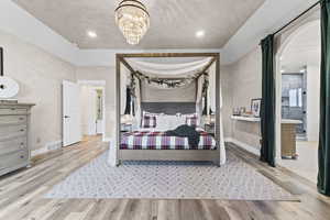 Bedroom featuring light wood finished floors, a chandelier, and recessed lighting