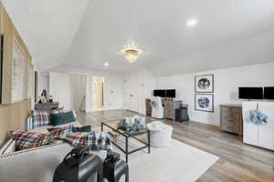 Living area with lofted ceiling, light wood-style floors, and recessed lighting