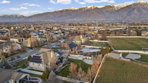 Aerial view of property and surrounding area featuring nearby suburban area and a mountainous background