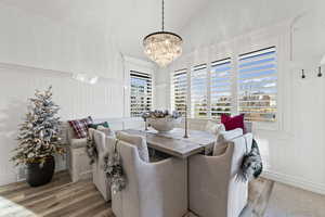 Dining area featuring light wood finished floors, lofted ceiling, and a chandelier
