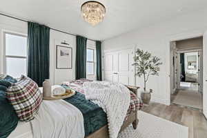 Bedroom with hardwood / wood-style flooring, a chandelier, and a closet