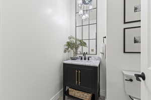 Half bathroom featuring vanity and baseboards