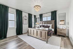 Bedroom with a chandelier and light wood finished floors