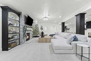 Carpeted living room featuring a fireplace, arched walkways, and recessed lighting