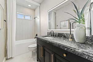 Bathroom featuring vanity and shower / bath combo with shower curtain