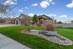 View of front facade featuring stone siding, stucco siding, and driveway