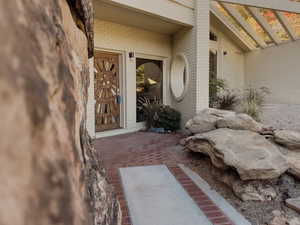 View of exterior entry featuring brick siding