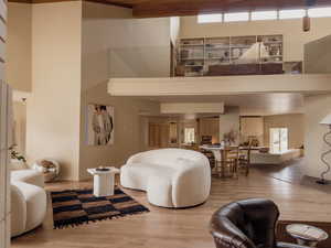 Living room with light wood-type flooring and a high ceiling