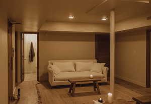 Living area with light wood finished floors and recessed lighting