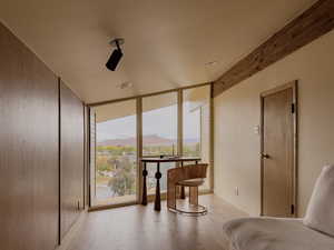 Sitting room featuring expansive windows, a mountain view, and light wood-style flooring
