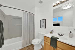 Primary bathroom featuring vanity and shower / bathtub combination with curtain