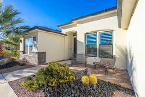 Entrance to property featuring stucco siding and stone siding