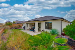 Back of property with a patio and stucco siding