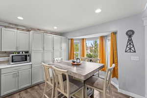 Dining area with dark wood-style floors and recessed lighting