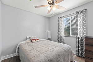 Bedroom with a ceiling fan and wood finished floors