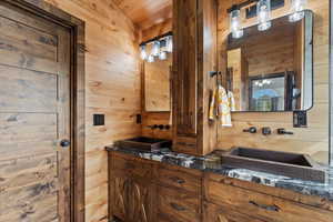 Bathroom with wood walls and double vanity