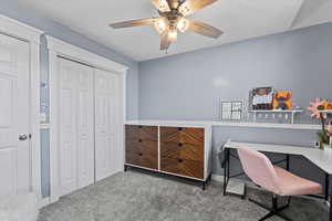 Office area with carpet flooring and ceiling fan