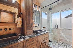 Bathroom featuring double vanity and a shower stall