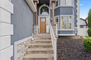 Doorway to property with stucco siding and stone siding