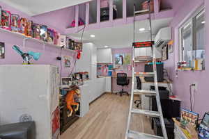 Misc room featuring an office area, light wood-style floors, a wall unit AC, and recessed lighting