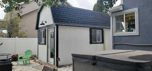 View of side of home featuring a hot tub