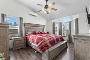 Bedroom featuring dark wood-style floors, lofted ceiling, ceiling fan, and a wall mounted AC