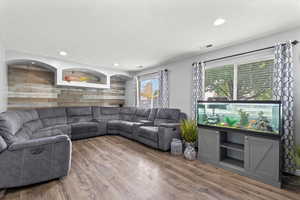 Living area with wood finished floors, recessed lighting, and wood walls