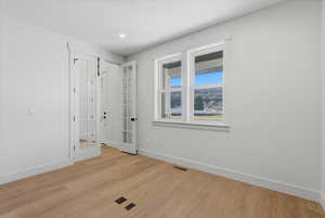 Unfurnished room with light wood finished floors, french doors, and recessed lighting