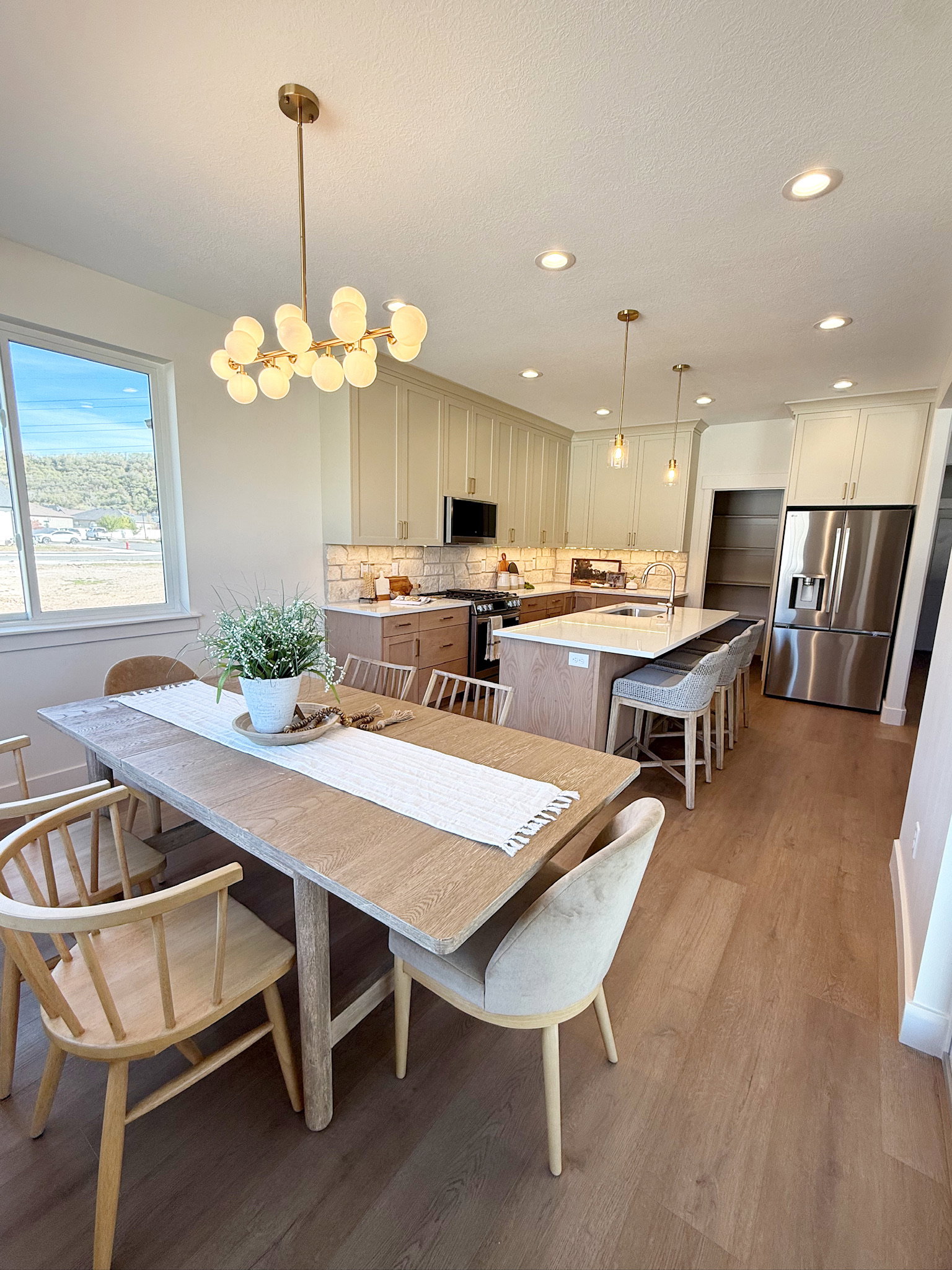 Dining area with light wood finished floors, a textured ceiling, and recessed lighting
