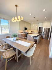 Dining area with light wood finished floors, a textured ceiling, and recessed lighting