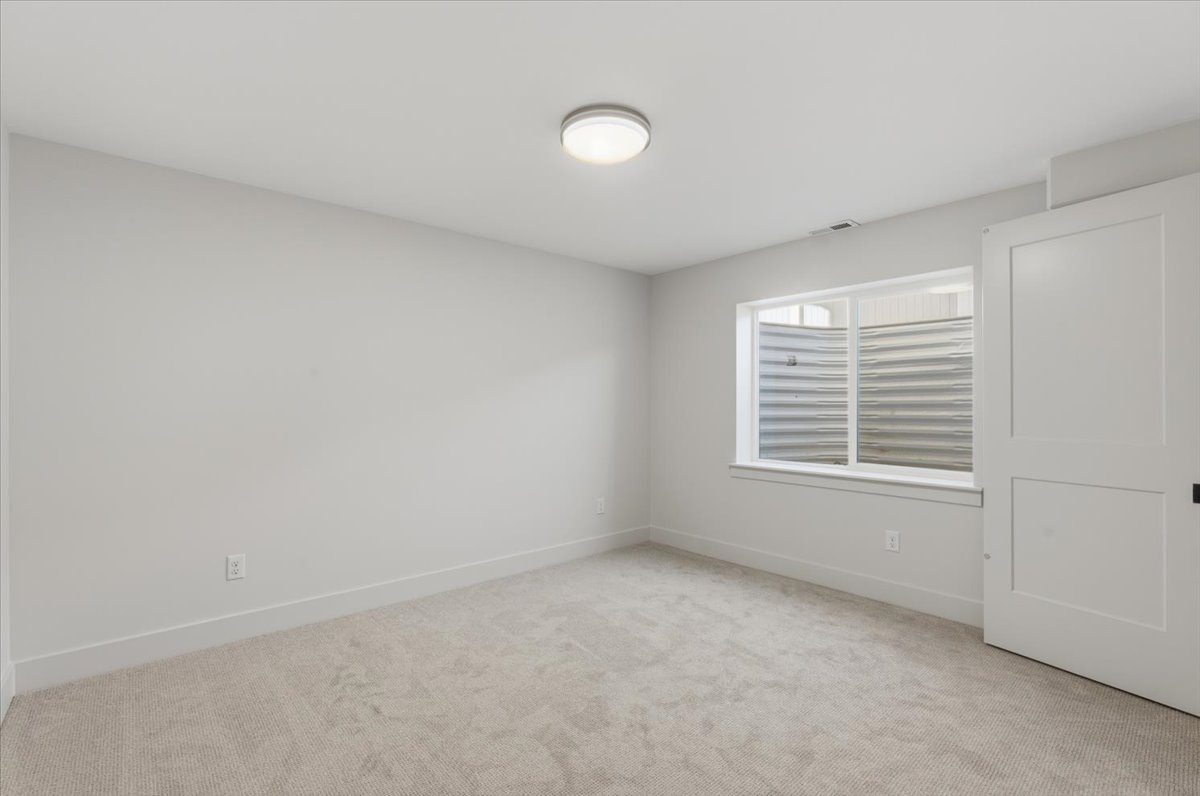 Empty room featuring baseboards and light colored carpet
