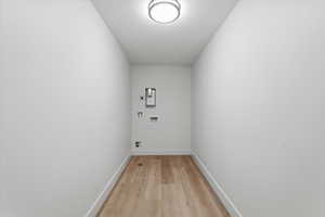 Laundry area featuring hookup for a washing machine, light wood-style flooring, and electric dryer hookup