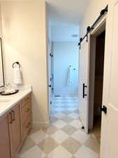 Bathroom with vanity and light flooring