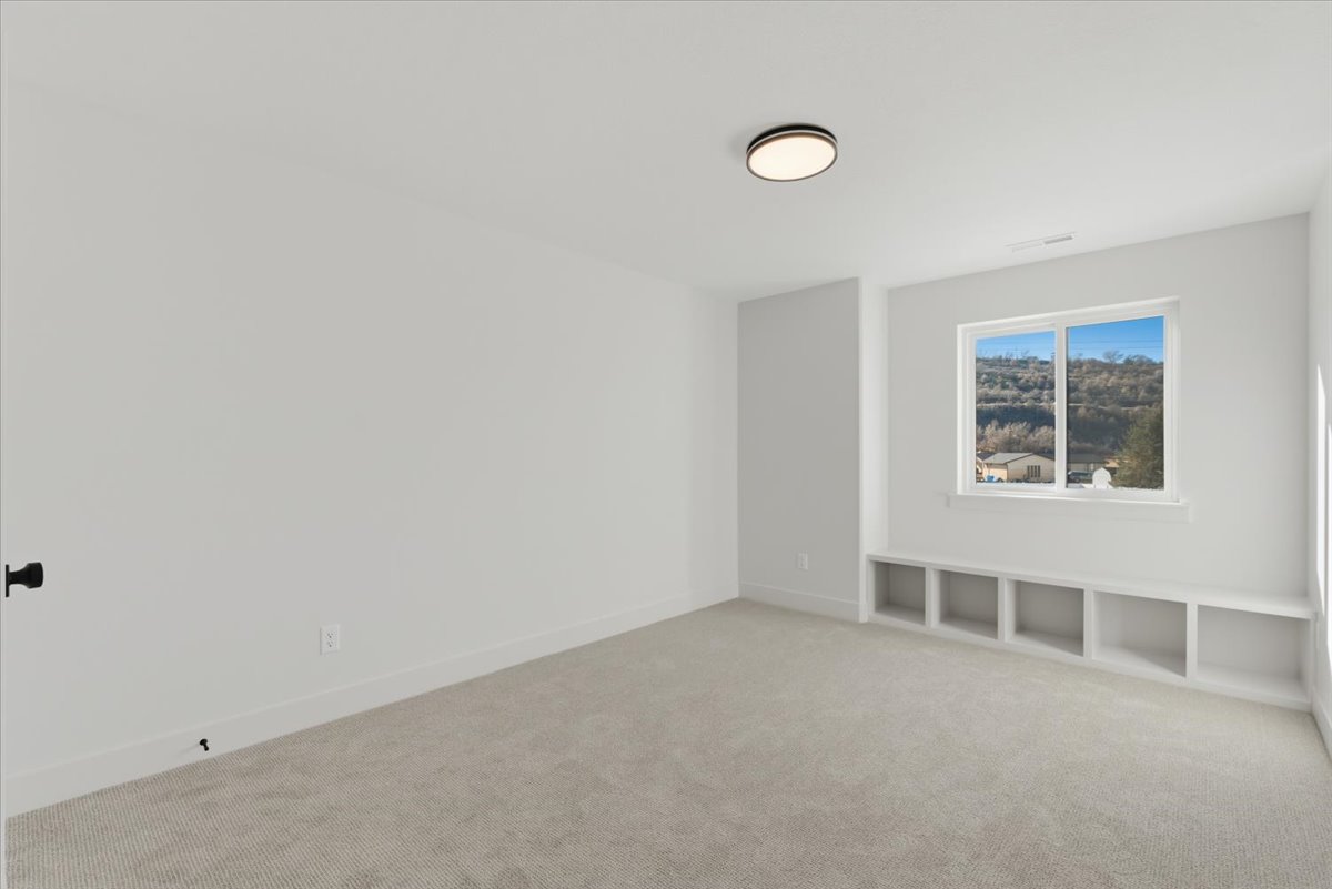 Carpeted spare room with baseboards
