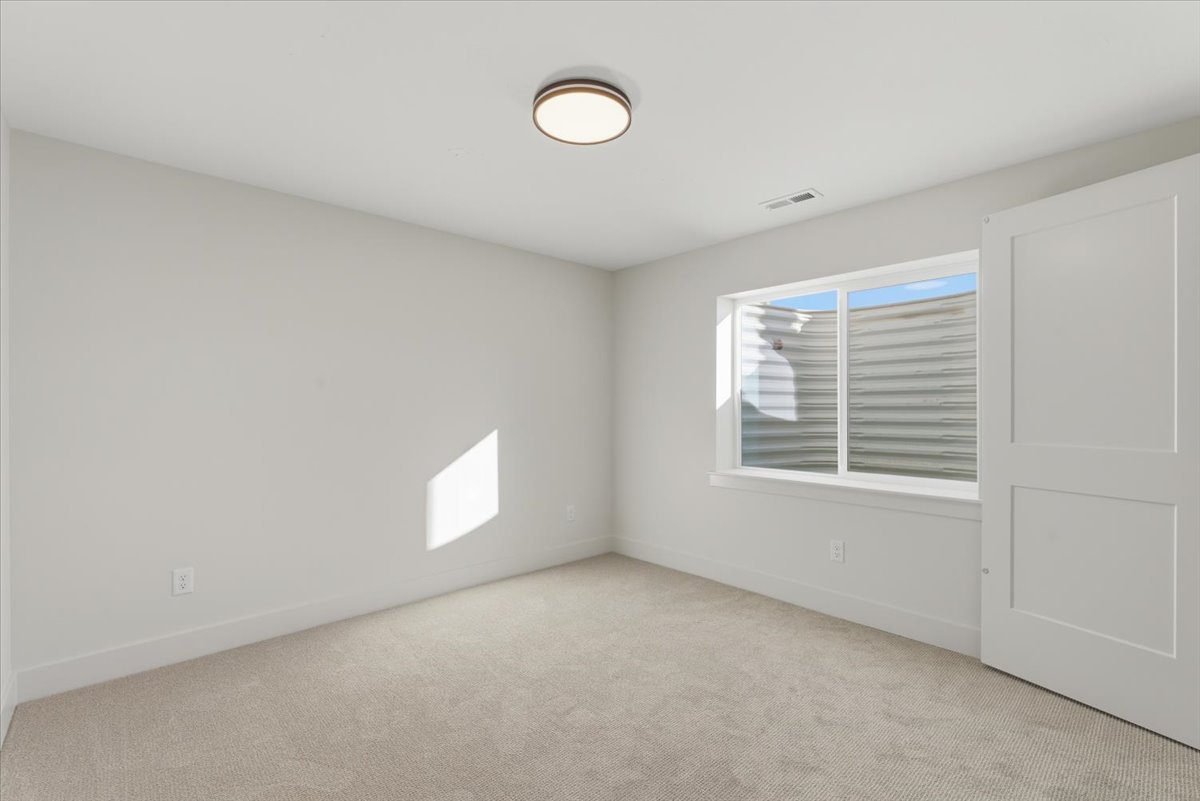 Spare room with baseboards and light carpet
