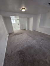 Carpeted spare room featuring baseboards