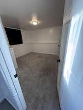 Carpeted spare room with a wainscoted wall