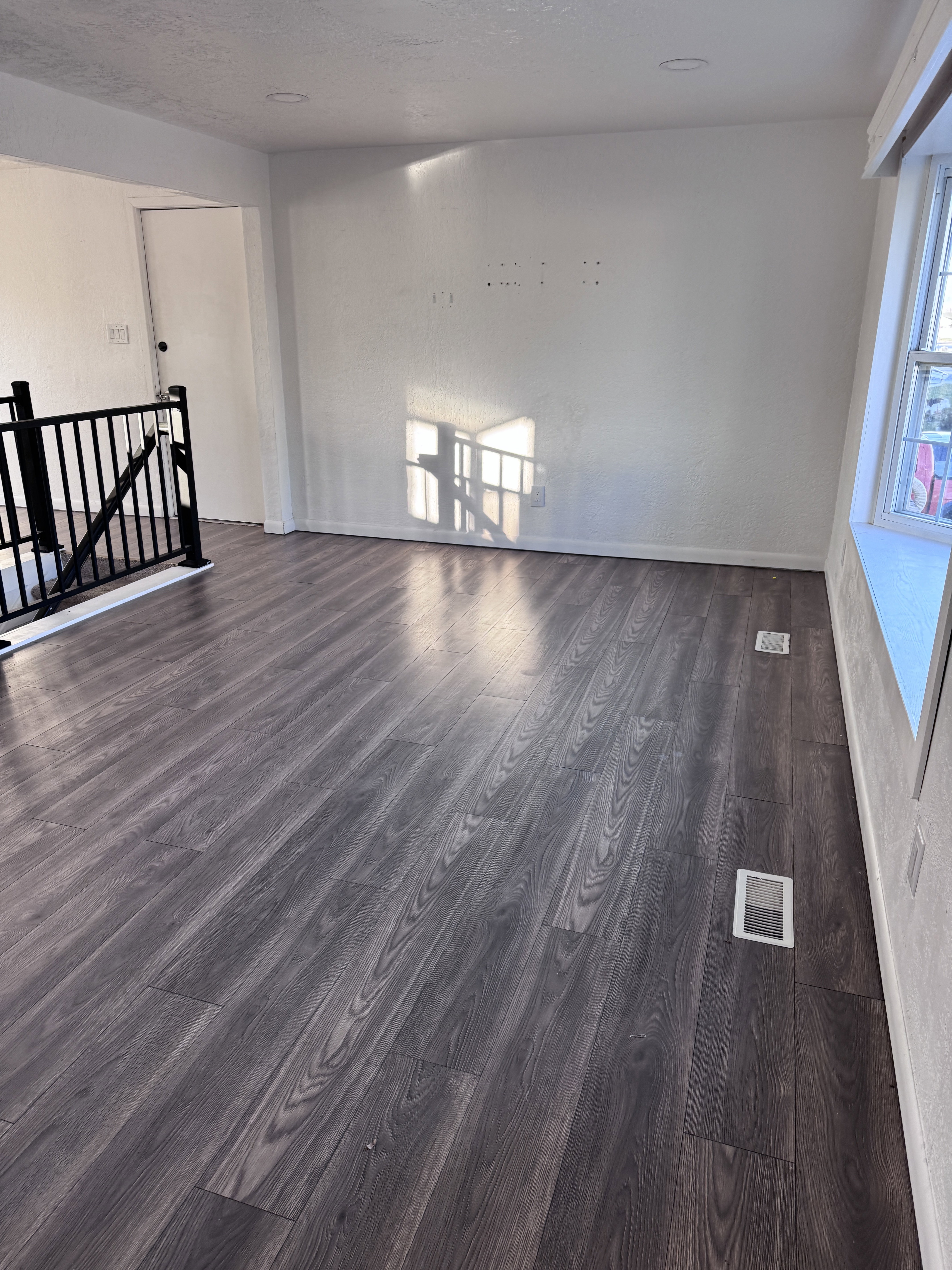 Unfurnished living room with dark wood-style flooring and a textured ceiling